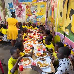 A staff serving children at Smile Community Centre Children's Home